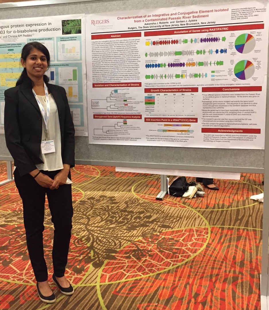 Aakansha Roberts standing next to a poster.